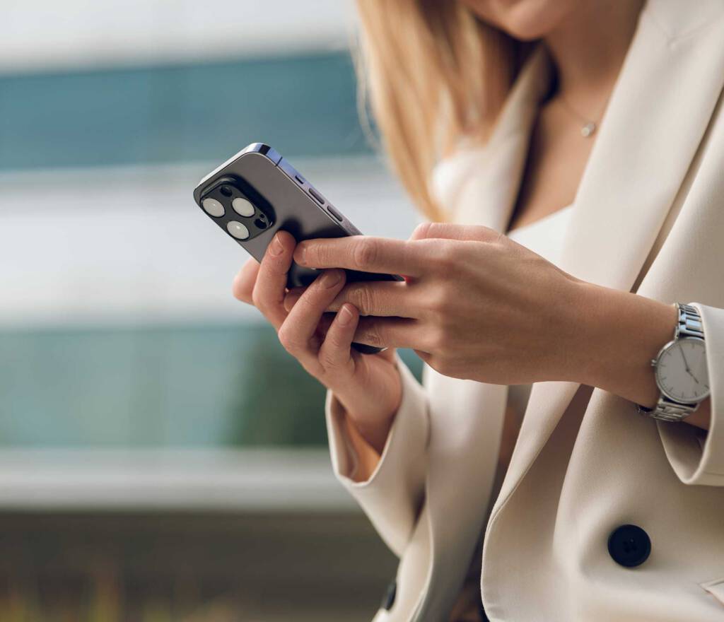 Eine Frau mit einem Smartphone in der Hand in Nahaufnahme.